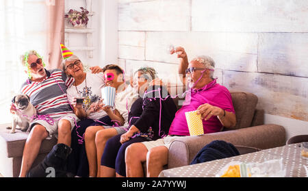 Family group with different ages and generations have fun together in a party - birthday event or carnival with grandfathers and grandson at home - ca Stock Photo