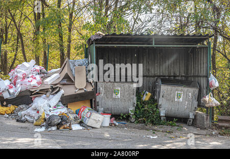 Junk outside empty trash container Stock Photo