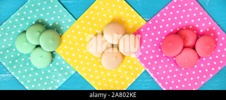 Header, colorful macarons or biscuits on different dotted napkins, topview Stock Photo