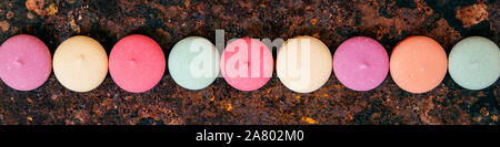 Panorama, variety of colorful cookies or biscuits in a line on rusty background, concept sweets Stock Photo