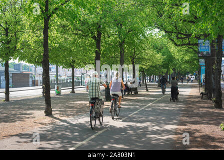 Cycle path, rear view in summer of a senior couple cycling along the Strandvagen cycle path in central Stockholm, Sweden. Stock Photo