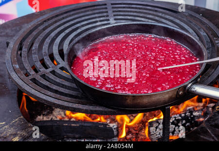Red cranberry sauce is cooked in a pan. Stock Photo