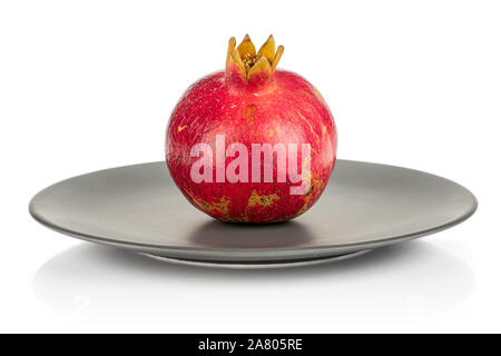 One whole fresh red pomegranate on gray ceramic plate isolated on white background Stock Photo