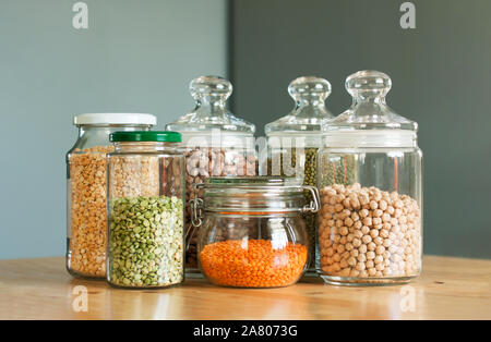 Glass jars with beans in the minimalistic interior. Peas, lentils, mung bean, beans and chickpeas as sources of vegetable protein. Zero waste concept, plastic-free, eco-friendly shopping, vegan Stock Photo