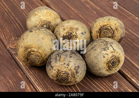 Group of six whole raw red beetroot on brown wood Stock Photo