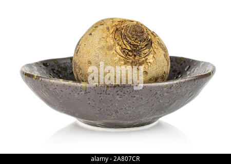 One whole raw red beetroot in dark ceramic bowl isolated on white background Stock Photo