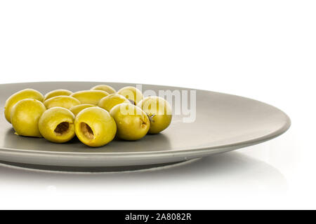 Lot of whole pitted green olive on gray ceramic plate isolated on white background Stock Photo