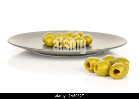 Lot of whole pitted green olive on gray ceramic plate isolated on white background Stock Photo