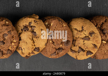 Group of five whole sweet brown cookie flatlay on grey stone Stock Photo
