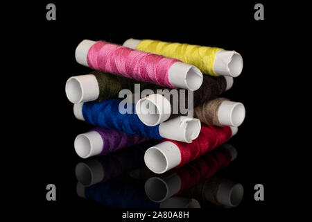 Group of eight whole sewing thread spool tower isolated on black glass Stock Photo