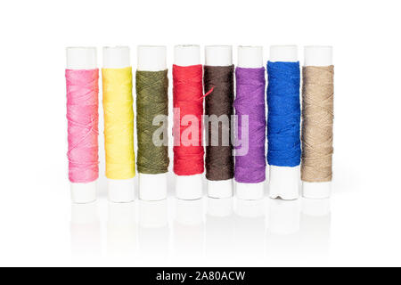 Group of eight whole sewing thread spool isolated on white background Stock Photo