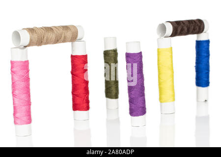 Group of eight whole upright sewing thread spool isolated on white background Stock Photo