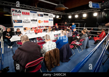 05 November 2019, Hamburg: At the side of Ismail Özen-Otto (5.f.l), Promoter Universum Box Promotion, Flavio Oleaga Mirabal (l-r), Matchmaker, Andreas Schenkat, Universum, Toni Kraft, Boxer, Artem Harutyunyan, Boxer, Artur Grigoryan, Trainer, Ali Ertan Toprak, Press Officer, Bernd Bauer, his son Leon Bauer, Boxer, and Frederik Ness, Team Sauerland, sit on the podium at a press conference in the Box-Gym Universum. On 09.11.2019 there will be a fight evening in Hamburg for the IBO International title in super light weight between Harutyunyan from Germany and Dumanov from Russia. Photo: Christian Stock Photo