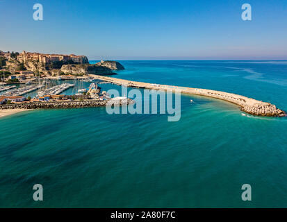 Aerial view of boats moored at the Port of Tropea, Calabria, Italy. Houses overlooking the sea. Beach and Sanctuary on the horizon. Italian coasts Stock Photo