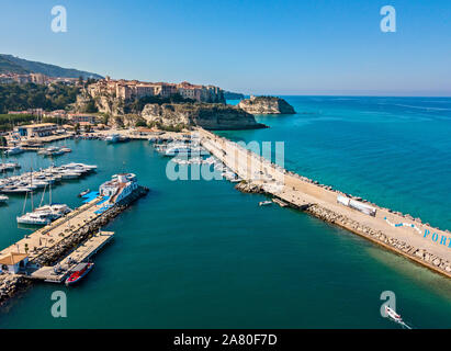 Aerial view of boats moored at the Port of Tropea, Calabria, Italy. Houses overlooking the sea. Beach and Sanctuary on the horizon. Italian coasts Stock Photo