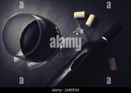 red wine bottle and glass on black marble stone background. top view Stock Photo