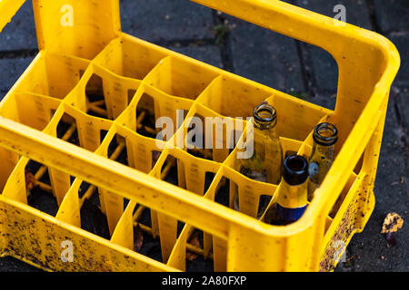 Several empty bottles in yellow plastic container Stock Photo