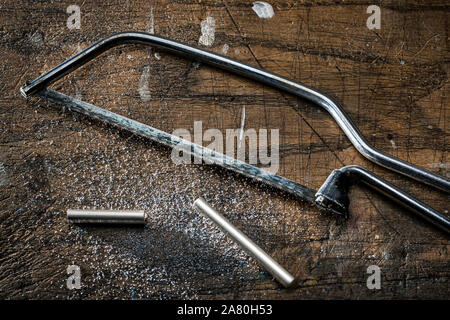 Junior hacksaw and cut silver tube. Stock Photo