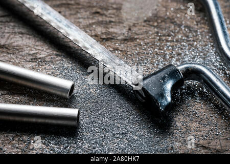 Junior hacksaw and cut silver tube. Stock Photo