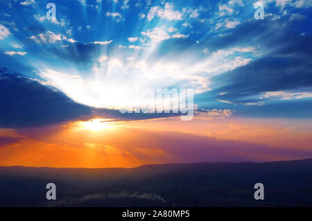 Sun shining through the low clouds of twilight Stock Photo
