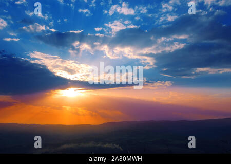 Sun shining through the low clouds of twilight Stock Photo