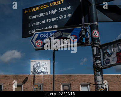 Scary Graffiti peering over wall in Shoreditch area of London Stock Photo