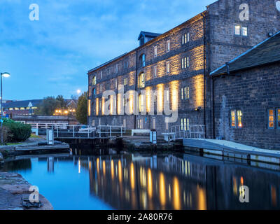 Floodlit Canal Warehouse reflected in the Leeds and Liverpool Canal at dusk Granary Wharf Leeds West Yorkshire England Stock Photo