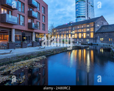 Floodlit Canal Warehouse reflected in the Leeds and Liverpool Canal at dusk Granary Wharf Leeds West Yorkshire England