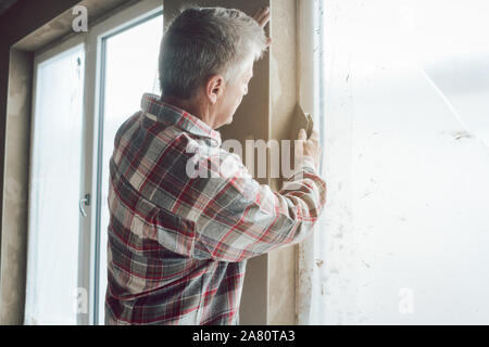 Plasterer working on a window opening Stock Photo