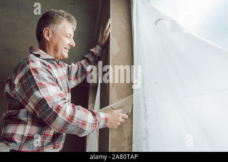 Plasterer working on a window opening Stock Photo