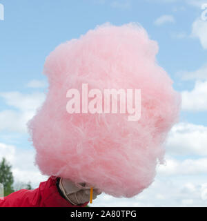 Sugar cotton wool on a stick in hand Stock Photo