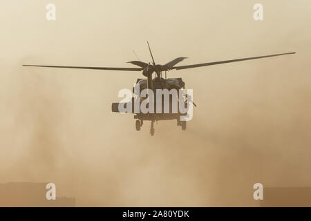 Military chopper takes off in combat and war flying into the smoke and chaos and destruction. Military concept of power, force, strength, air raid. Po Stock Photo