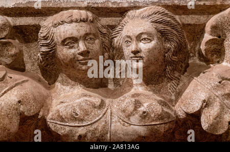 Stone relief sculpture of two young women in the walls of the Doge's Palace in Venice Italy Stock Photo