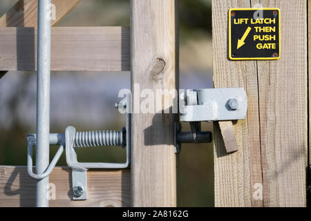 Please close gate with lifting handle and latch sign on walking rambling route in countryside uk Stock Photo
