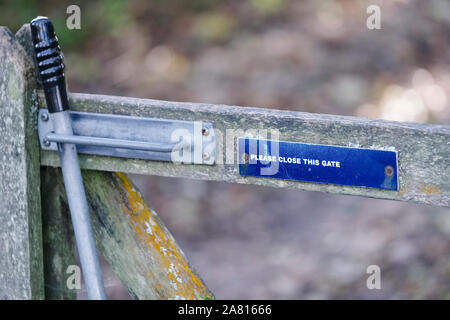 Please close gate with lifting handle and latch sign on walking rambling route in countryside uk Stock Photo