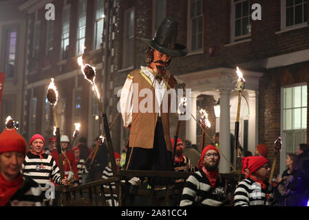 Participants parade through the town of Lewes in East Sussex during an annual bonfire night procession held by the Lewes Bonfire Societies. Stock Photo