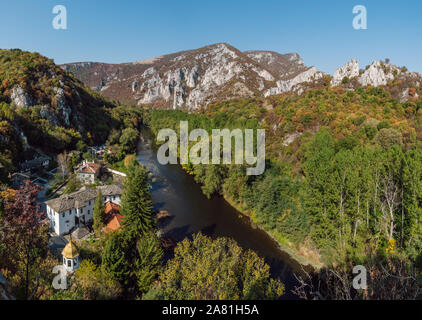 Panorama of the Iskar River Gorge in the autumn and the Cherepish Monastery. River valley, autumn forest, orthodox monastery and rocky mountain. Stock Photo