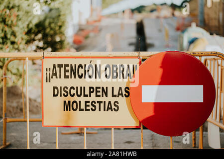 Traffic sign prohibited the passage and fences of works with phrase in Spanish 'Attention works, sorry for the inconvenience' Stock Photo