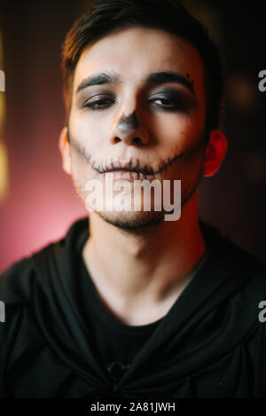 Young man with Halloween make-up looks at the camera Stock Photo