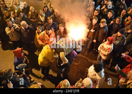 Participants from the village of Ottery St Mary in Devon carry traditional burning tar barrels through the streets of the village on bonfire night. Stock Photo