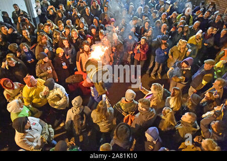 Participants from the village of Ottery St Mary in Devon carry traditional burning tar barrels through the streets of the village on bonfire night. Stock Photo