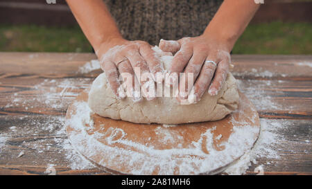 A young woman kneads the dough with her hands. Homemade bread baking. Stock Photo