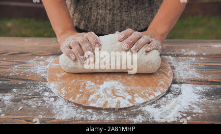 A young woman kneads the dough with her hands. Homemade bread baking. Stock Photo