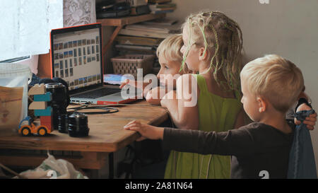 Children are browsing photos on a laptop. Stock Photo