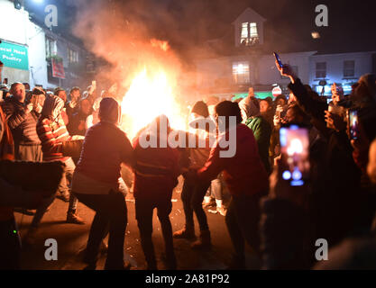 Participants in the village of Ottery St Mary in Devon carry traditional burning tar barrels through the streets of the village on bonfire night. Stock Photo