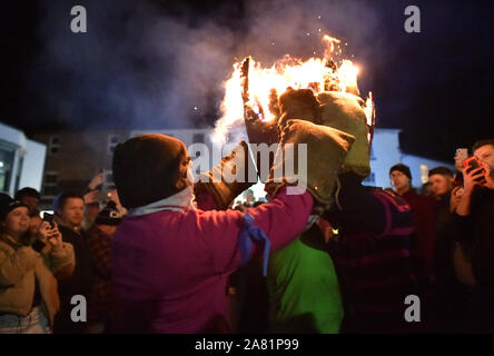 Participants in the village of Ottery St Mary in Devon carry traditional burning tar barrels through the streets of the village on bonfire night. Stock Photo