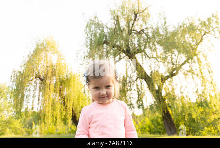 Funny angry face of little cute girl looking in camera Stock Photo