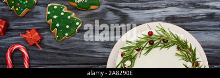 top view of christmas pie, candy canes, gifts and cookies on dark wooden table Stock Photo
