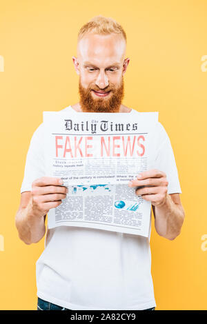 cheerful man reading newspaper with fake news, isolated on white Stock ...