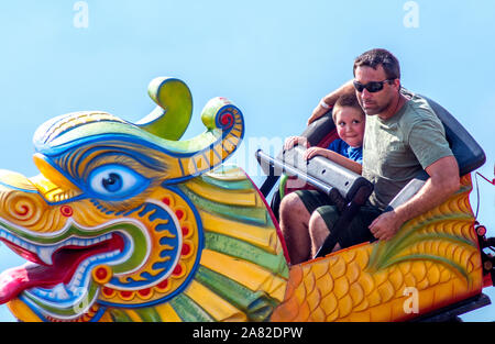 A young boy is happy dad is close by as he rides on his very first